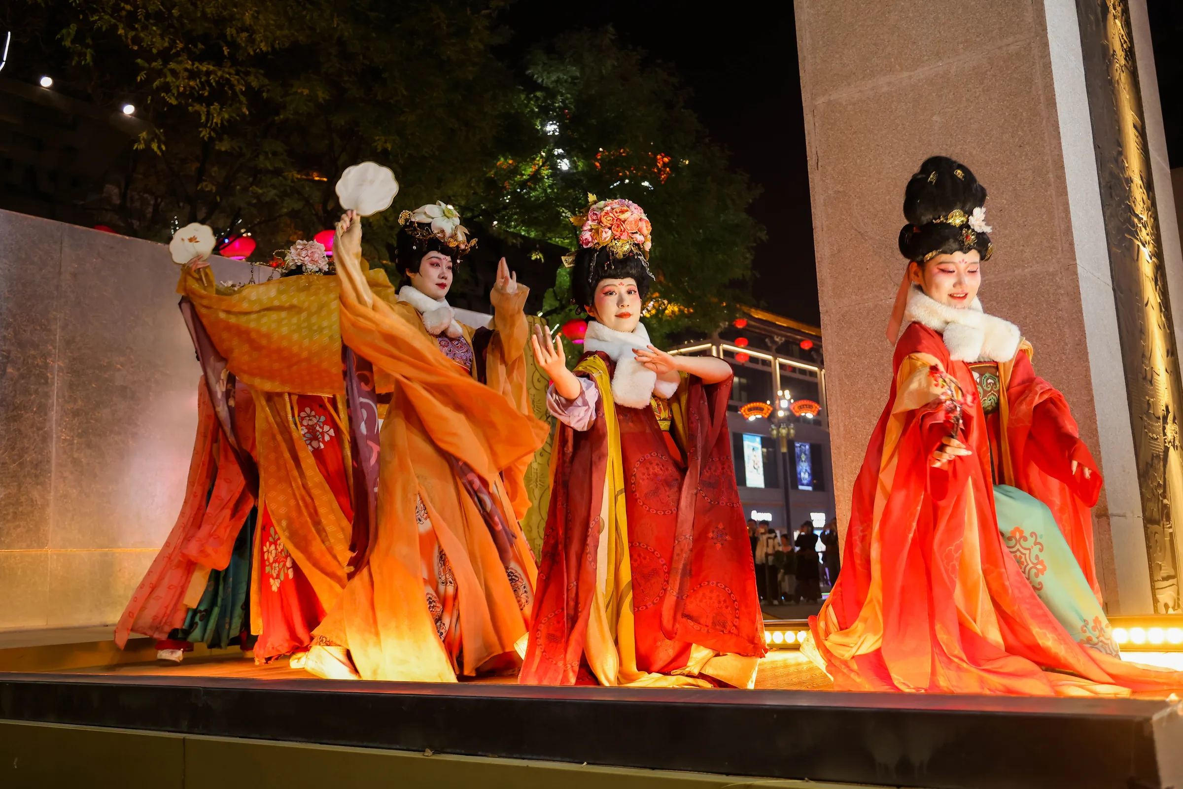 Performers in Tang dynasty costume on an outdoor stage at night