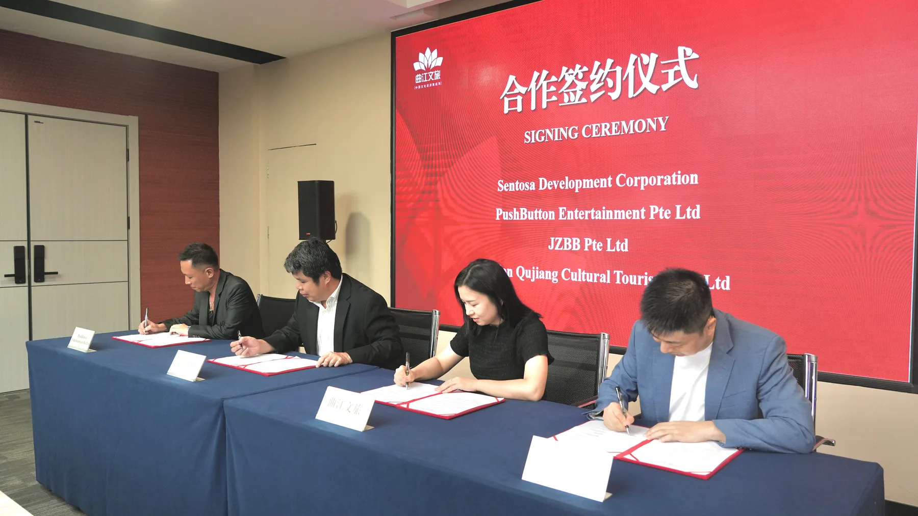 Signatories signing the letter of intent at a long table