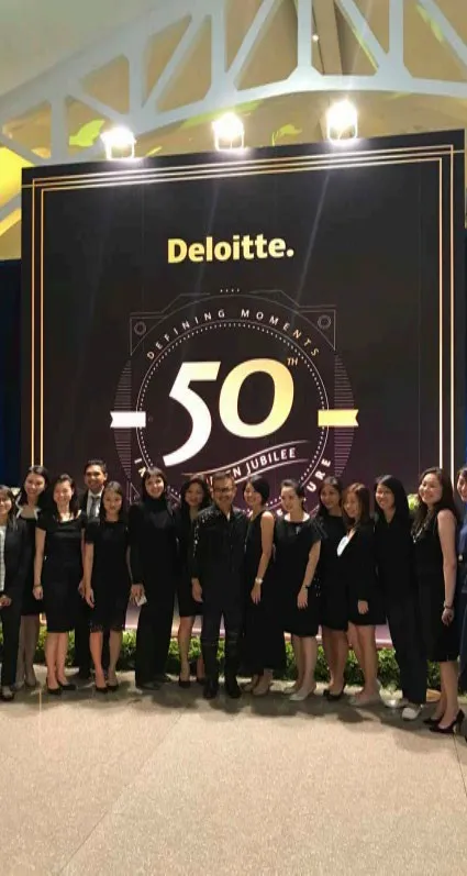 Guests in front of the Deloitte 50 backdrop