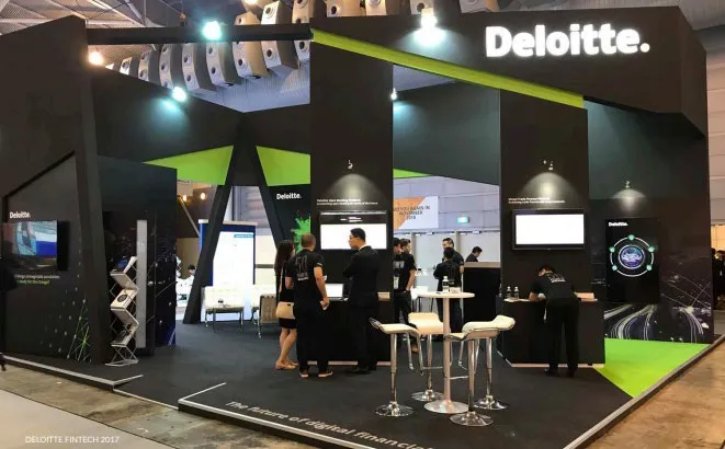 Deloitte Singapore exhibition booth with green lighting and screens