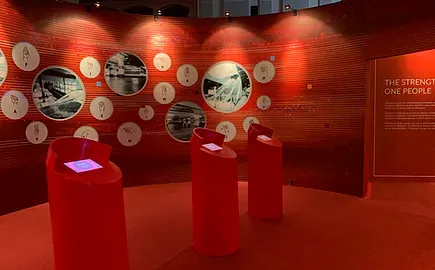 Red room with circular photos and touchscreen plinths