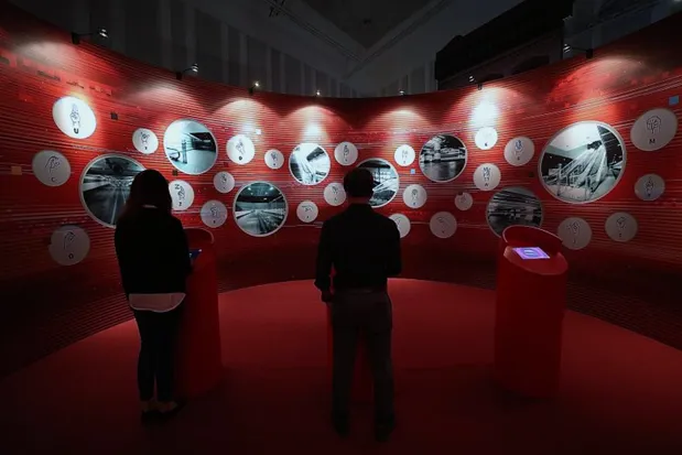 Visitors in a red room with circular photo displays