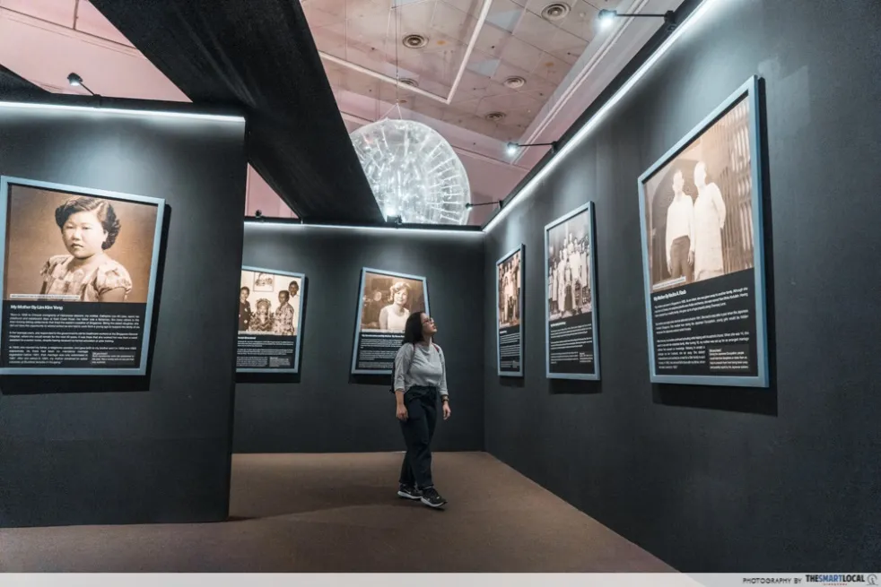 Visitor in a gallery of framed portrait photographs