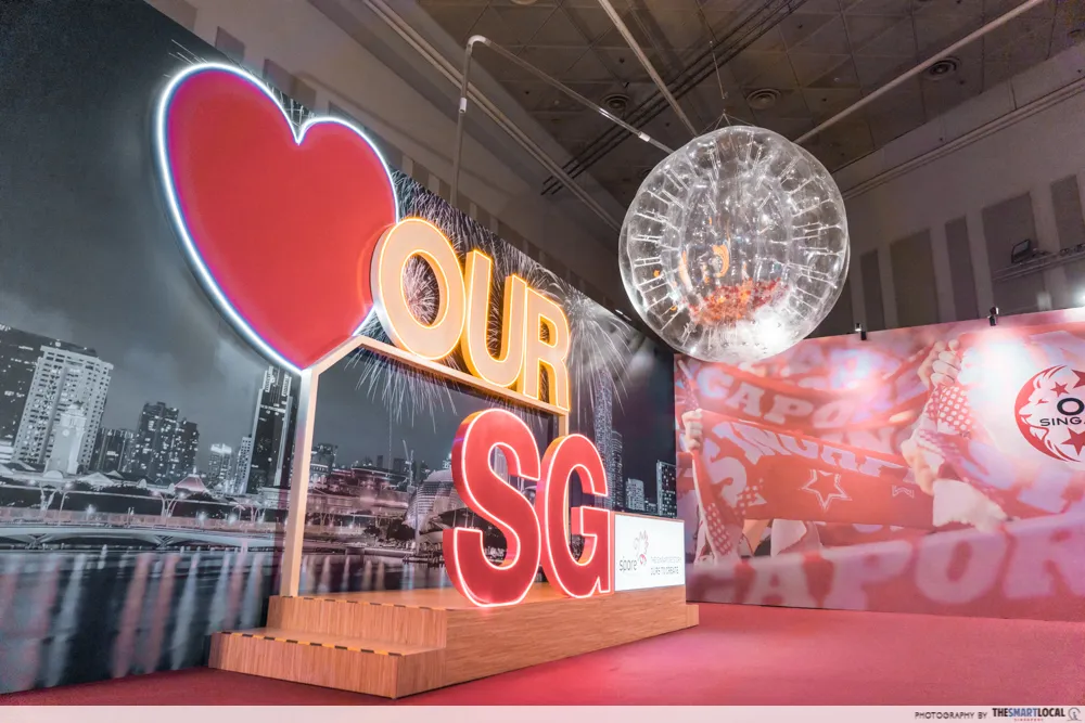 OUR SG heart sign in front of a Singapore skyline and fireworks backdrop