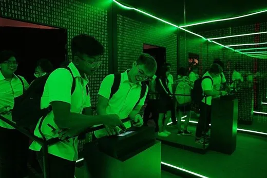 Students solving puzzles in a green-lit escape room